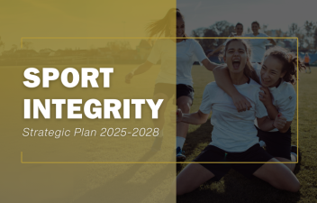 A rectangle that is transparent gold on the left half and a picture of women playing soccer on the right. Over the gold block on the left, appears the words "Sport Integrity, Strategic Plan 2025-2028".