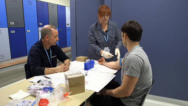 A tourniqet is applied to the arm of the athlete